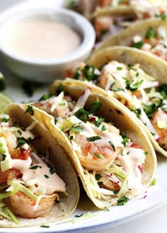 shrimp tacos on a plate with dipping sauce