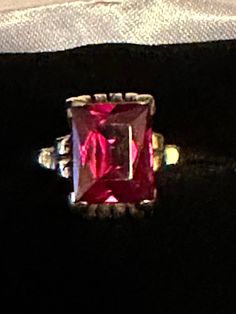 "For your consideration, a very vintage 10K red glass ring.  This beautiful piece is 10K and hallmarked and guaranteed to be such. Also, there is a maker's mark of \"RS\".  The red solitaire stone is emerald cut glass which was popular in the 30s and 40s.  The stone measures 10mm x 8mm and is set in a scroll setting on all four sides.  This fabulous ring is a size 5 3/4 and weighs in a at 4.28 grams. It is one fabulous vintage ring with lots of history yet to made!" Classic Red Ruby Ring With Prong Setting, Classic Red Birthstone Ring, Red Art Deco Hallmarked Jewelry, Collectible Red Ruby Rings, Collectible Red Ruby Jewelry, Classic Red Rings, Classic Red Ruby Ring With Vs Clarity, Collectible Classic Ruby Jewelry, Collectible Red Gemstone Rings