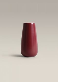 a red vase sitting on top of a table