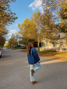 a woman is walking down the street with her feet in the air and she's smiling