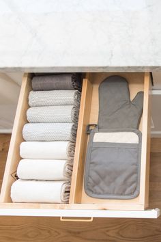 an open drawer with towels and other items in it