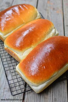 two loaves of bread sitting on top of a cooling rack next to each other