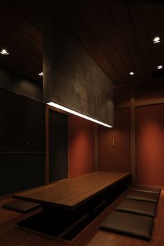 an empty room with benches and lights on the ceiling is lit by recessed lighting