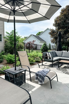 an outdoor patio with lounge chairs, umbrellas and tables in the back yard on a sunny day