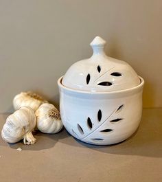 two garlic cloves sitting next to a white bowl