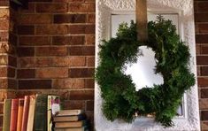 a wreath is hanging on the mantle next to books