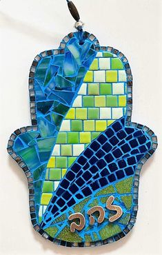 a mosaic hamsa hanging on the wall