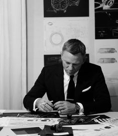 a man in a suit sitting at a table writing