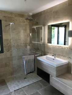 a bathroom with a sink, mirror and shower stall in it's own area