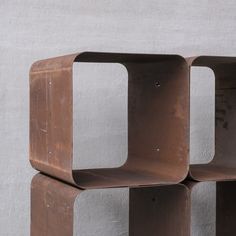 three metal shelves are stacked on top of each other in front of a white wall