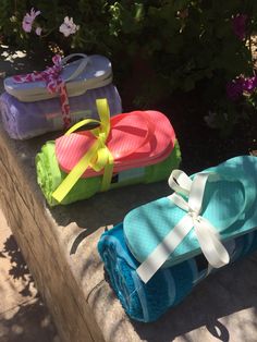 three pairs of flip flops sitting on top of towels