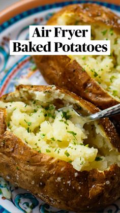 two baked potatoes on a blue and white plate with a fork in it, sitting next to each other