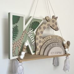 a wooden giraffe hanging from the side of a wall next to a plaque