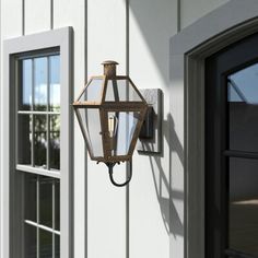 a light that is attached to the side of a building next to a door and window