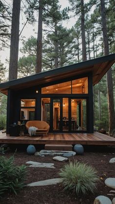 a small cabin in the woods surrounded by pine trees and rocks, with an open floor plan