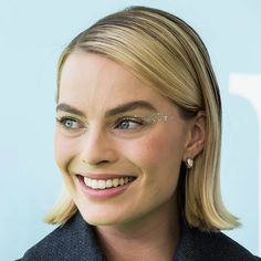 a woman with blonde hair and glasses smiling