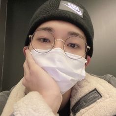 a young man wearing a mask and glasses covers his face with a white cloth to protect him from the cold