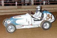 a man driving a race car in an arena