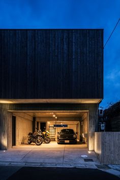 two motorcycles are parked in the garage with their lights on and one motorcycle is parked next to it