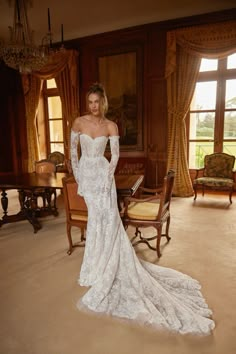 a woman in a white wedding dress posing for the camera with her hands on her hips