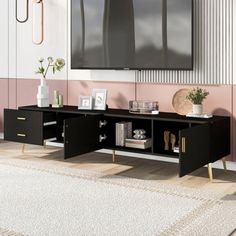 a living room with pink walls and white carpeted flooring, a black entertainment center unit in the middle