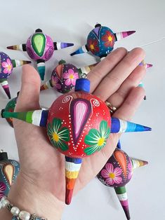 a hand is holding several colorful painted objects