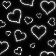 many small hearts are arranged in the shape of dots on a black background with white lights