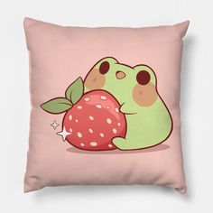 a pink pillow with a green frog holding an apple on it's back,