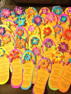 colorful flip flops with flowers on them are laid out for guests to take home