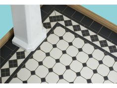 a black and white tiled floor next to a toilet