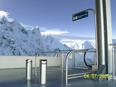 an airport with mountains in the background and metal railings on either side that lead up to it