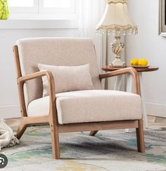 a chair sitting on top of a rug next to a table with a fruit bowl