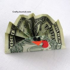 an origami bird made out of one dollar bill with scissors in its beak