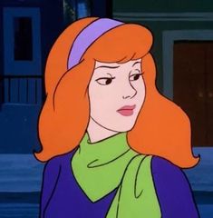 a woman with red hair wearing a green scarf and purple jacket in the cartoon scooby show