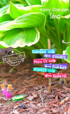 a small wooden sign sitting on the ground in front of some green leafy plants