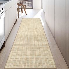 a kitchen area with a rug on the floor