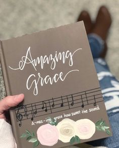 someone holding up a book that says amazing grace