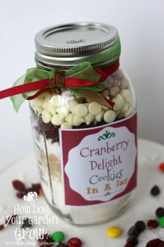 a jar filled with white and red candies on top of a table next to candy