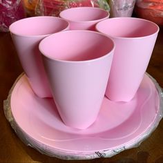 pink cups are sitting on a plate with plastic wrappers around the edges and bottom