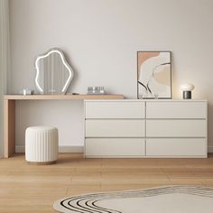 a white dresser sitting on top of a wooden floor next to a mirror and lamp