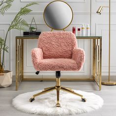 a pink chair sitting in front of a mirror on top of a wooden desk next to a white rug