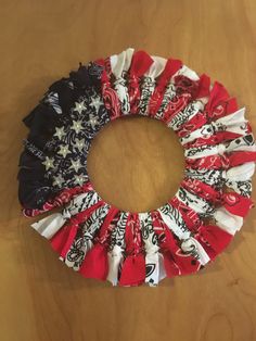 an american flag wreath made out of old t - shirts on a wooden table top