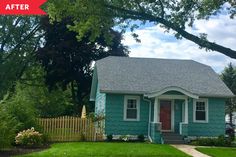 a small blue house sitting in the middle of a lush green yard next to a tree