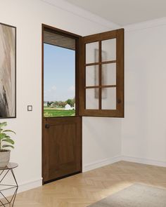 an open wooden door in a white room with a painting on the wall behind it