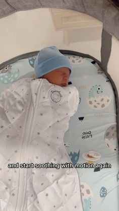 a baby is sleeping in a crib wearing a blue hat and white jacket with stars on it