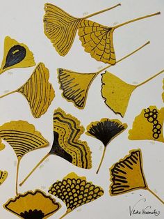 some yellow and black leaf shapes on a white surface with writing underneath them that says,