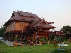 a large wooden house sitting on top of a lush green field