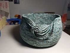 a woven basket sitting on top of a table next to a blue bowl with a knot in it