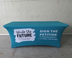 a blue table with a sign that reads write the future and is sitting in front of a white wall