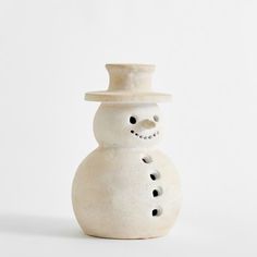 a ceramic snowman with a white hat on it's head and nose is standing in front of a white background